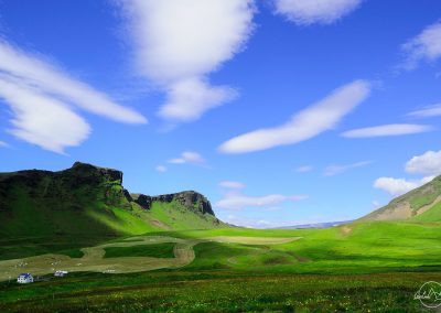 Ultra green landscape, deep blue sky, mountains on the left, one road in the middle