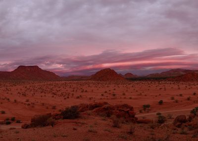 Panoramic view of dry landscape with stones in Namibia with a purple light for sunset
