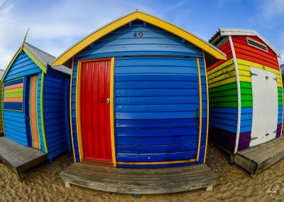Colorful red and blue bathing boxes on Brighton beach with fish eye distorsion