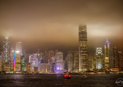 HongKong cityline at night with red boat on the water