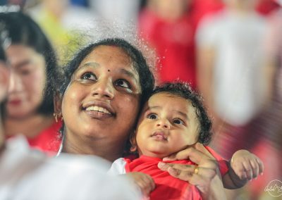 mother with young child in her arms looking at fireworks and smiling