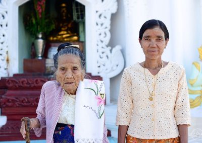 Elegant old woman posing with her daughter in a pagoda in Myanmar