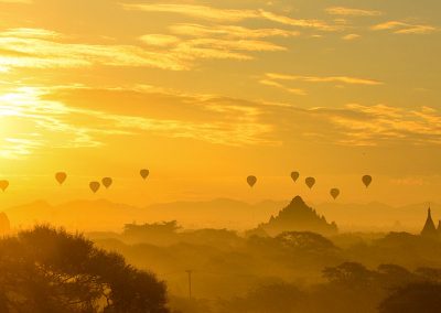 Panorama sunrise over Bagaan temples with the siljhouette of more than ten balloons in the air