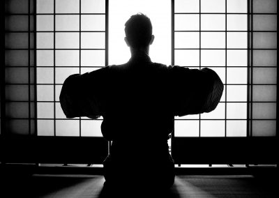 Silhouette of a man in kimono opening a japanese window
