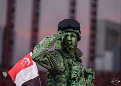 Soldier saluting on a mobile column with Singapore flag in the background