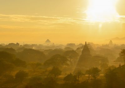 Sun rising through temples and trees, view from the top of a temple