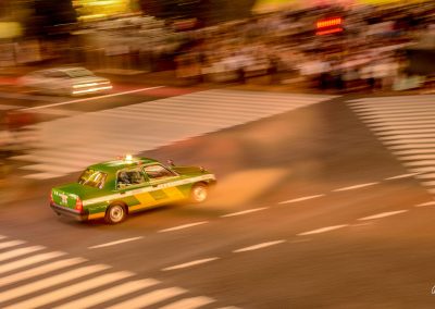 Green taxi driving on the crossroad of Shibuya, viewed from above