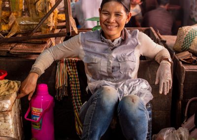 Portrait of a woman sitting in a market smiling